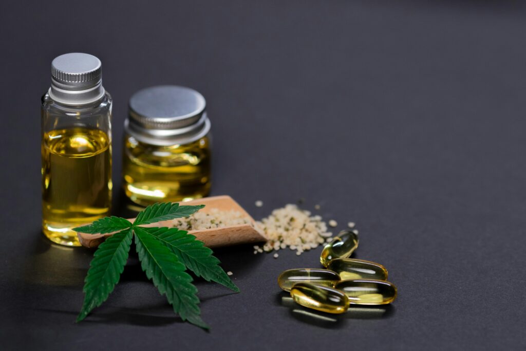 pexels-photo-7667731-7667731 Assorted cannabis products including hemp seeds, oil, and capsules on dark background.
